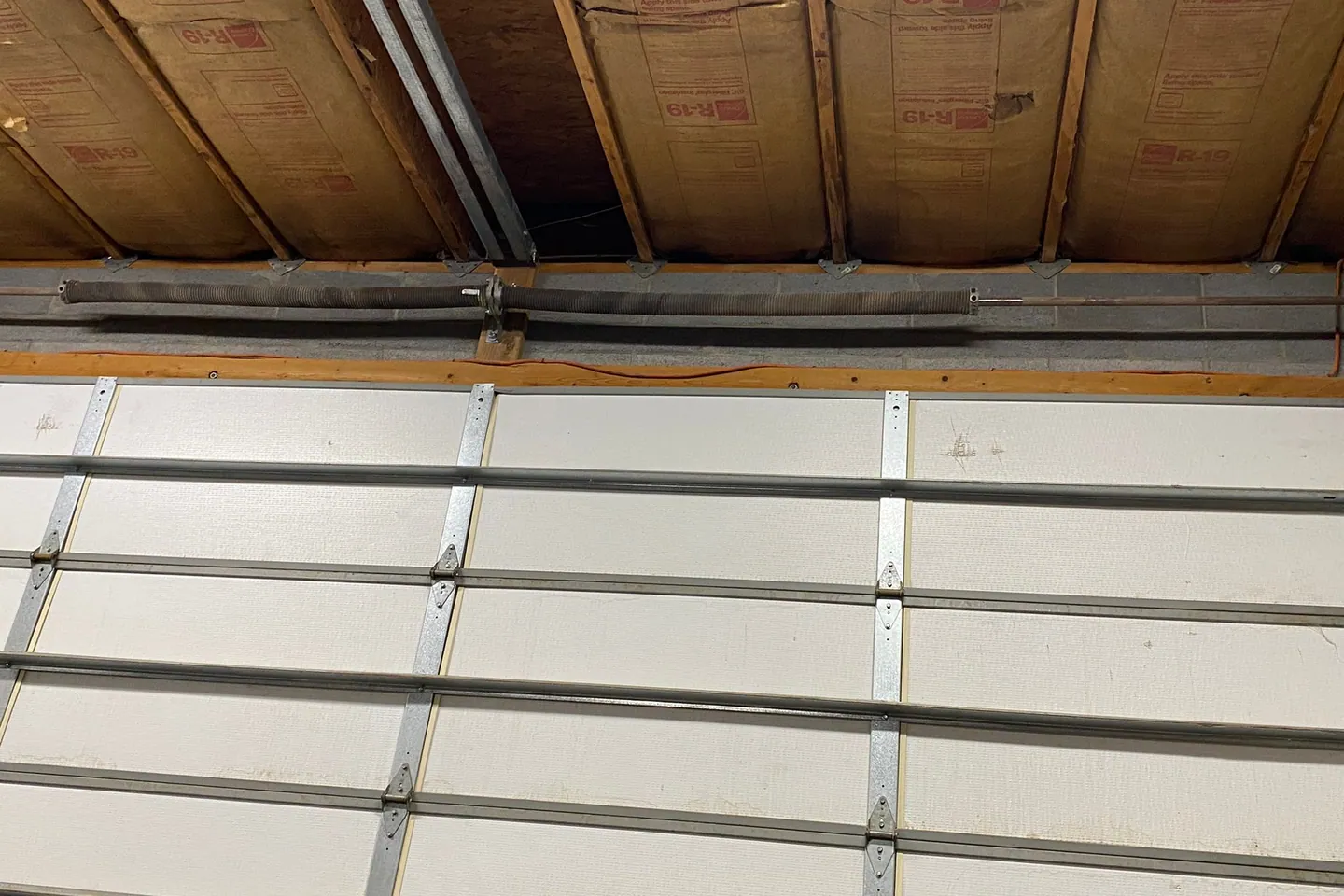 Technician measuring a garage door spring system