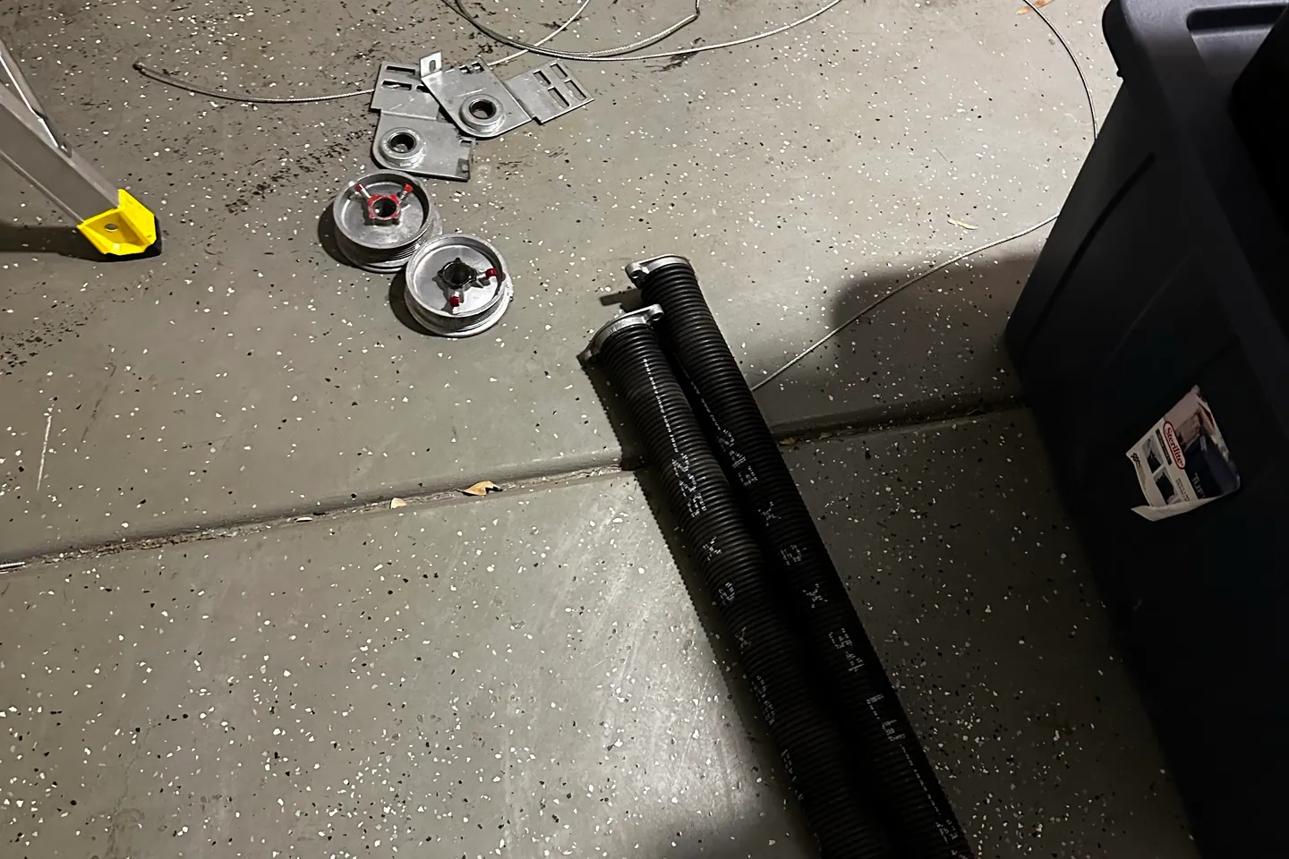 Close view of a garage door spring and lifting cable