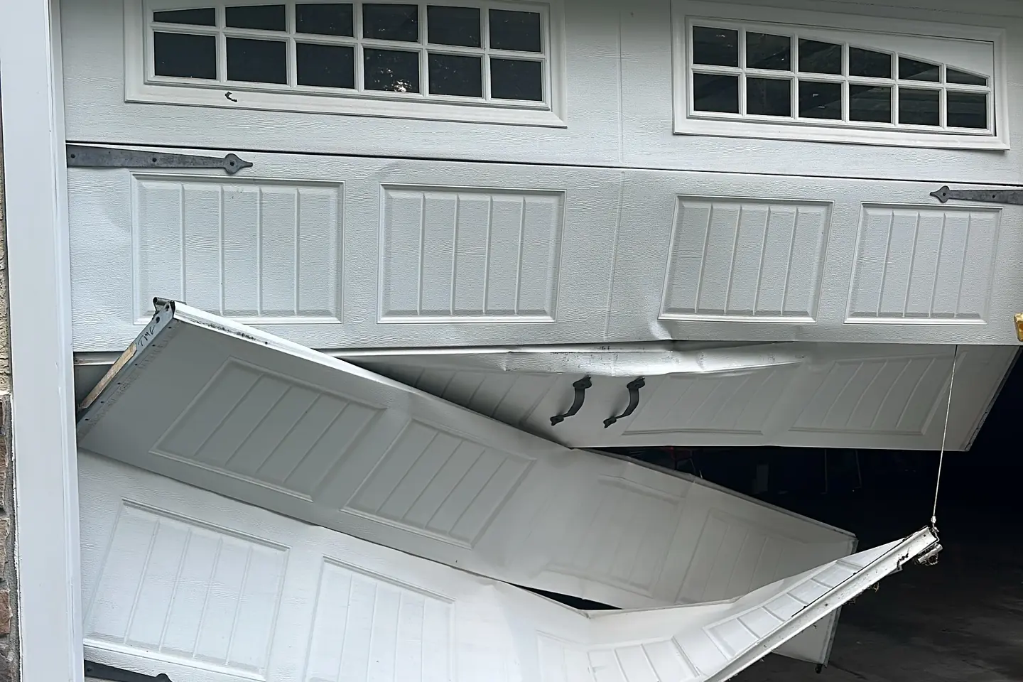 Garage door track and roller hardware being inspected