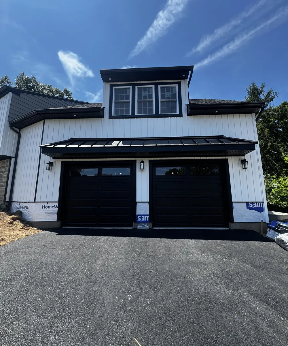 Two completed black garage doors on the new garage